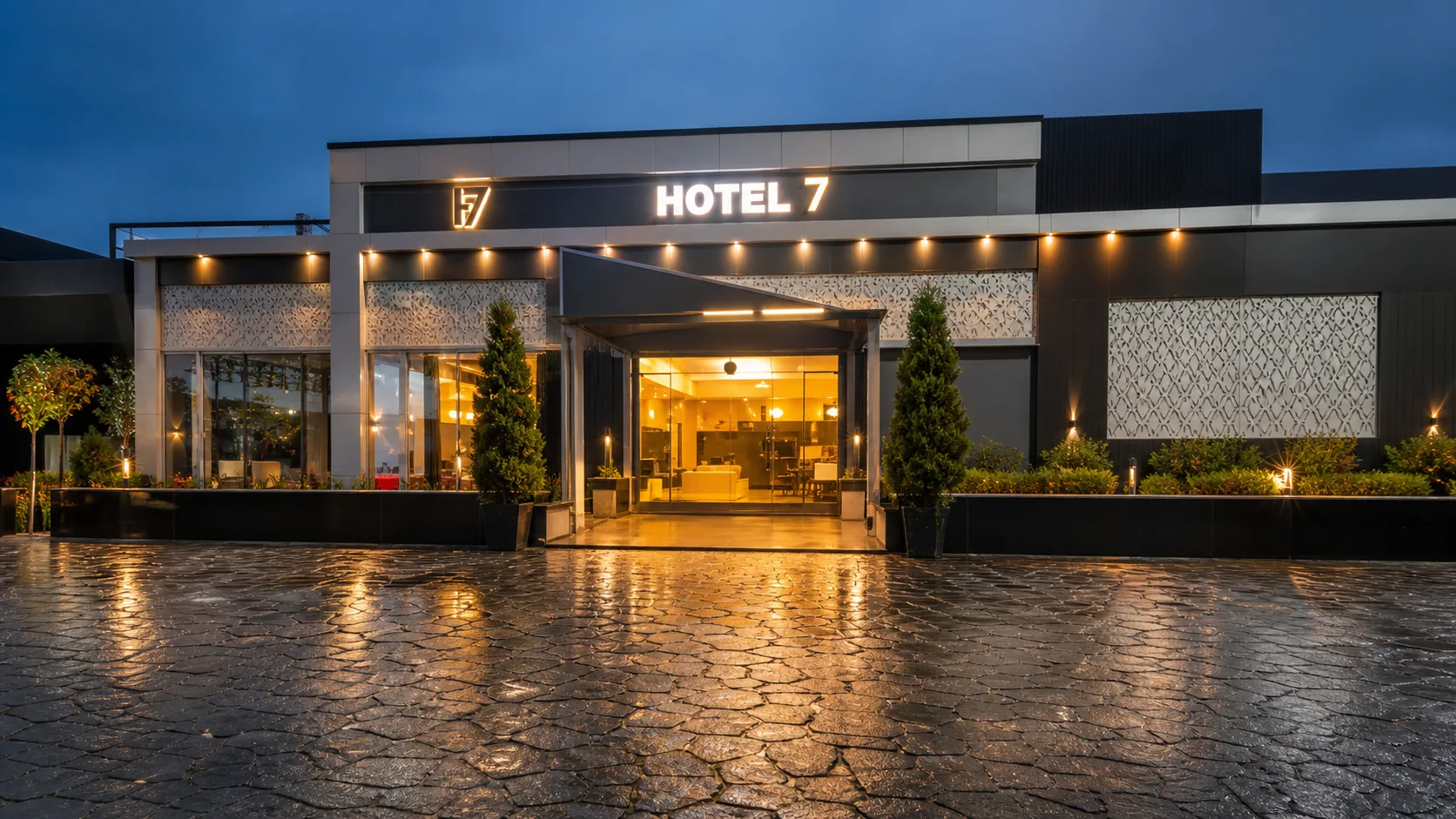 Hotel 7 Piduguralla exterior with illuminated entrance at dusk