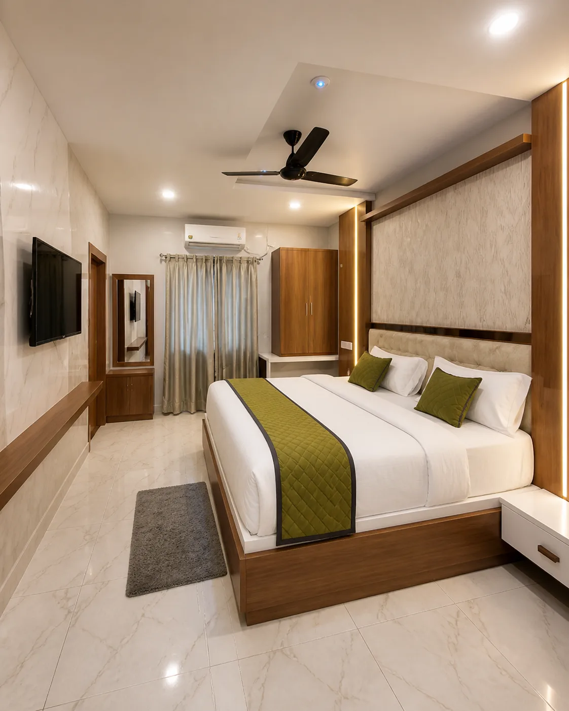 Karthikeya Grand guest room with warm timber and upholstered bed detailing
